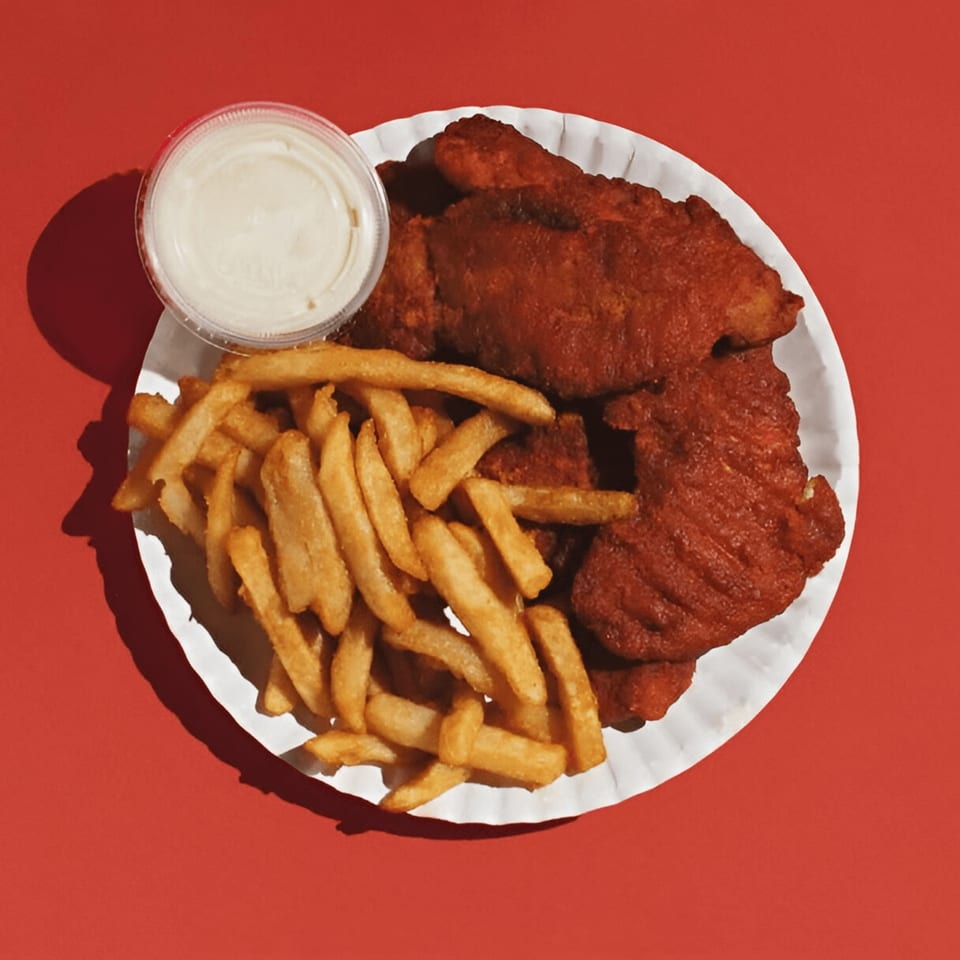 Joey's Pizza: A plate of crispy red chicken tenders, golden fries, and a side of dipping sauce.